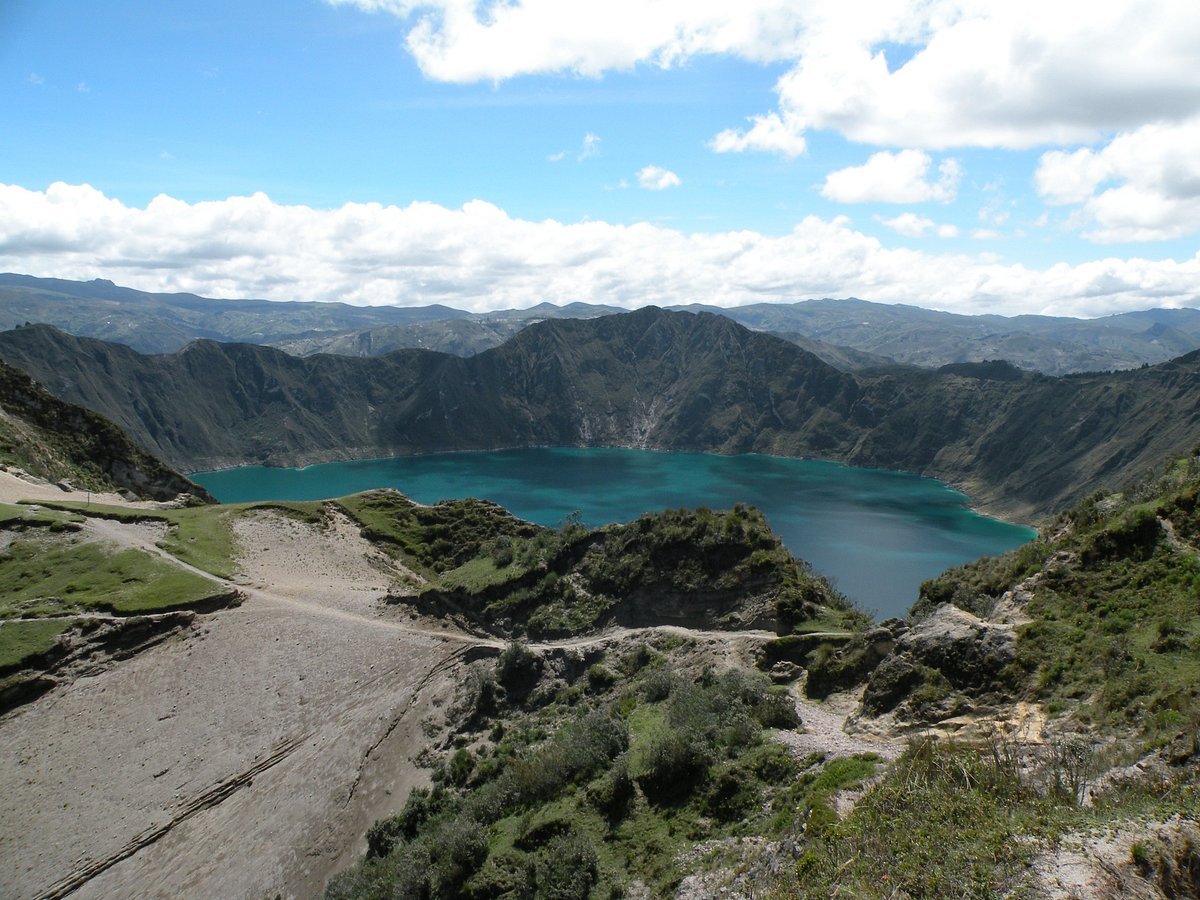 A hiker on a trail overlooking a vast valley in the Andes.